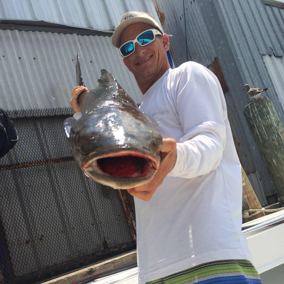 Galveston Fishing Charter Captain Shane Cantrell holding mouth of fish up to camera