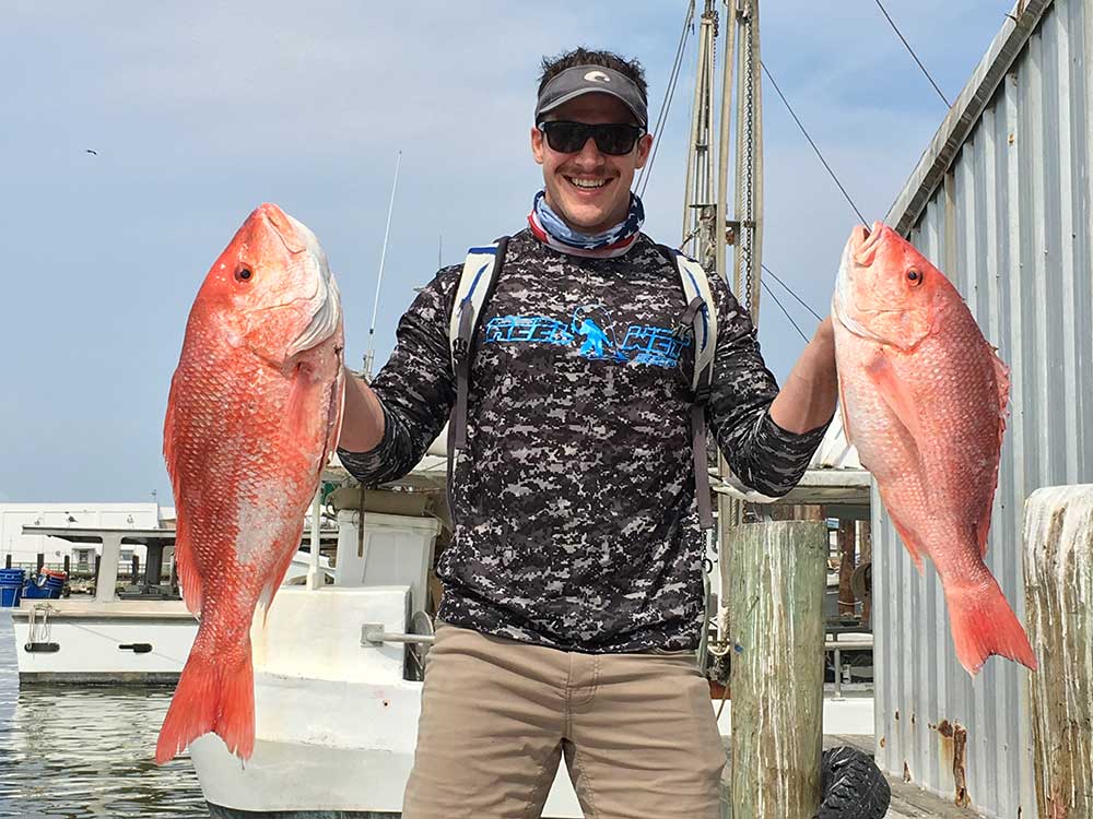 Angler holds up his Galveston Red Snapper catch from a Red Snapper fishing trip