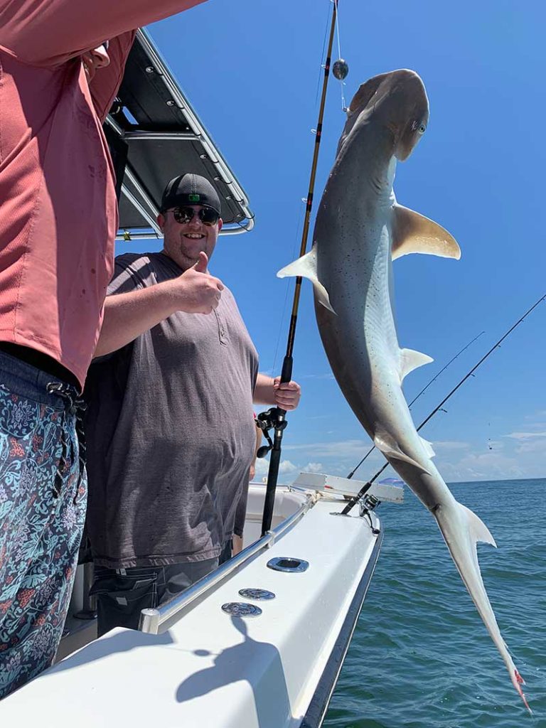 Angler posing with a shark he caught on a Galveston shark fishing trip