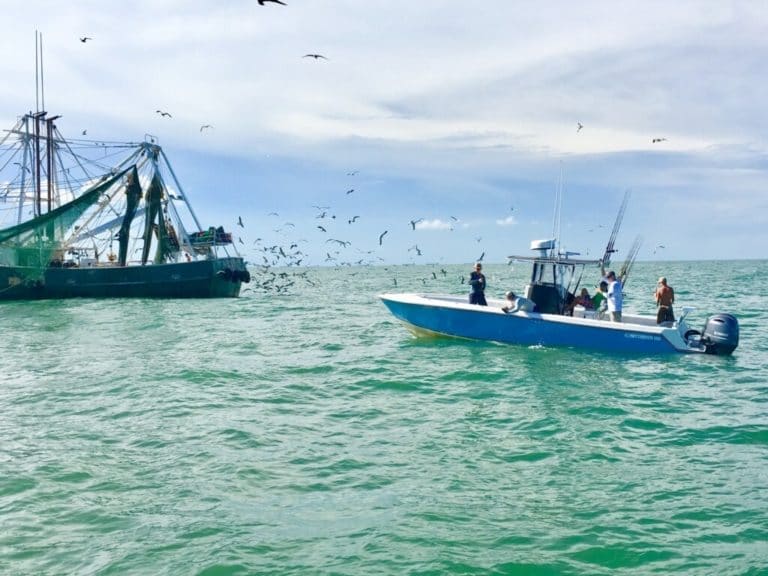 Galveston fishin charter boat alongside a shrimping boat