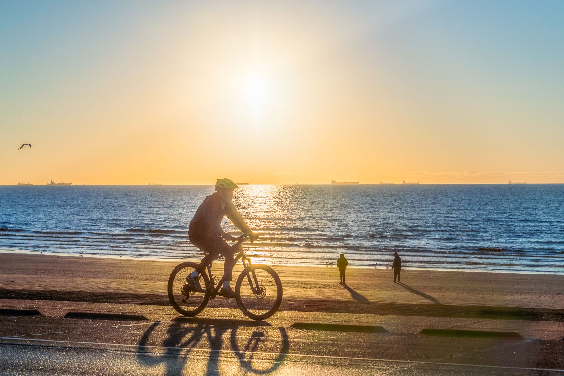 Man rides his bike on the seawall in Galveston during spring break.