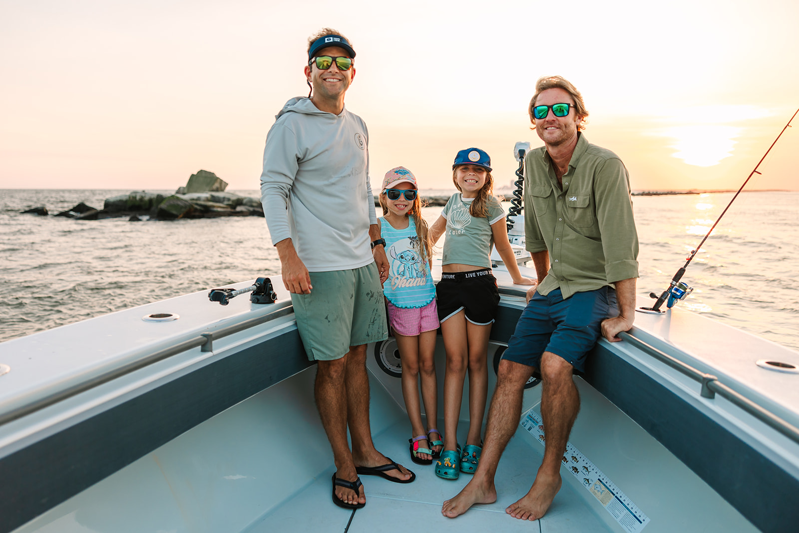 A young family smile and poses from the bow of a Galveston Fishing Boat.