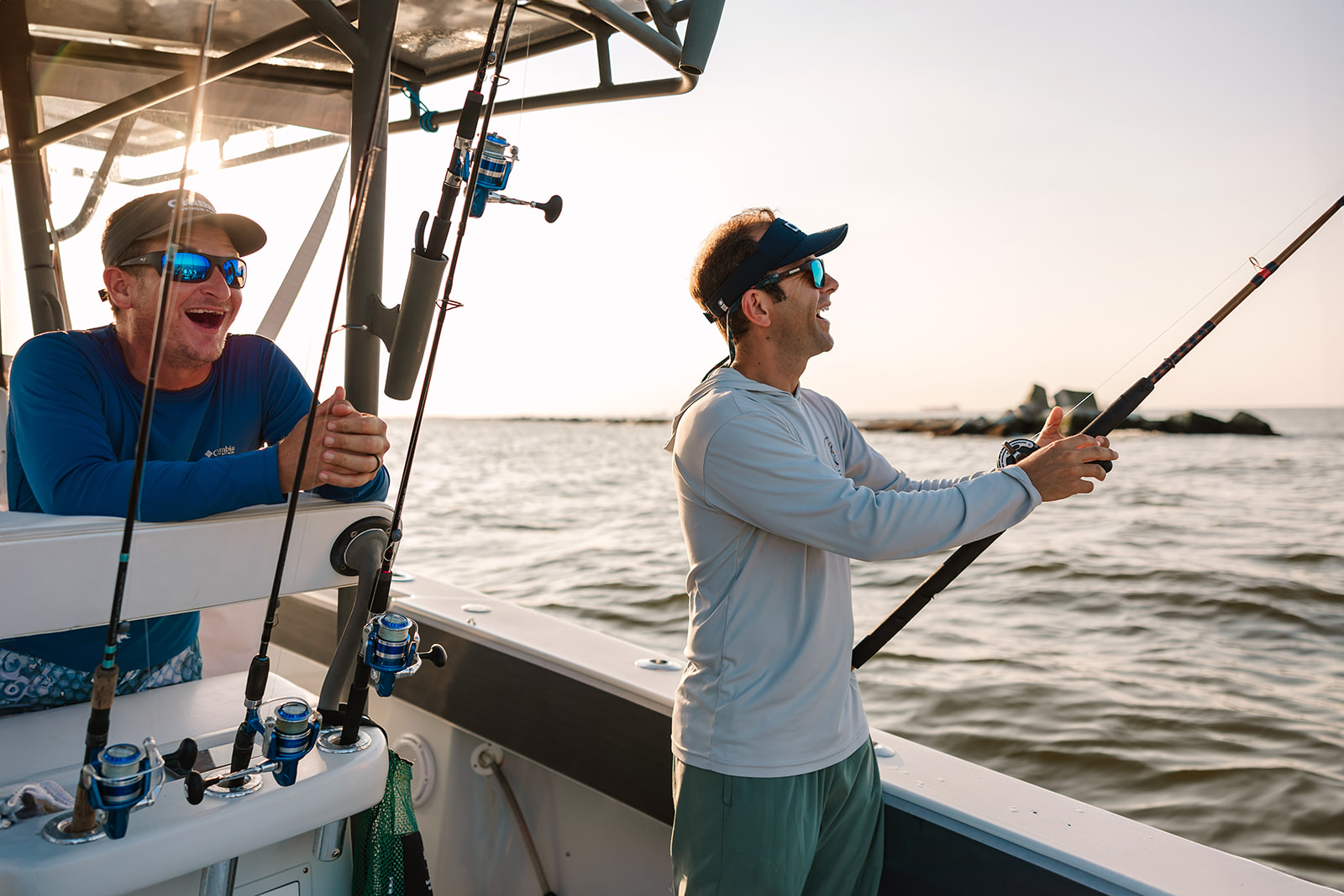 Man casts his fishing line over the side of a Galveston Fishing Boat.