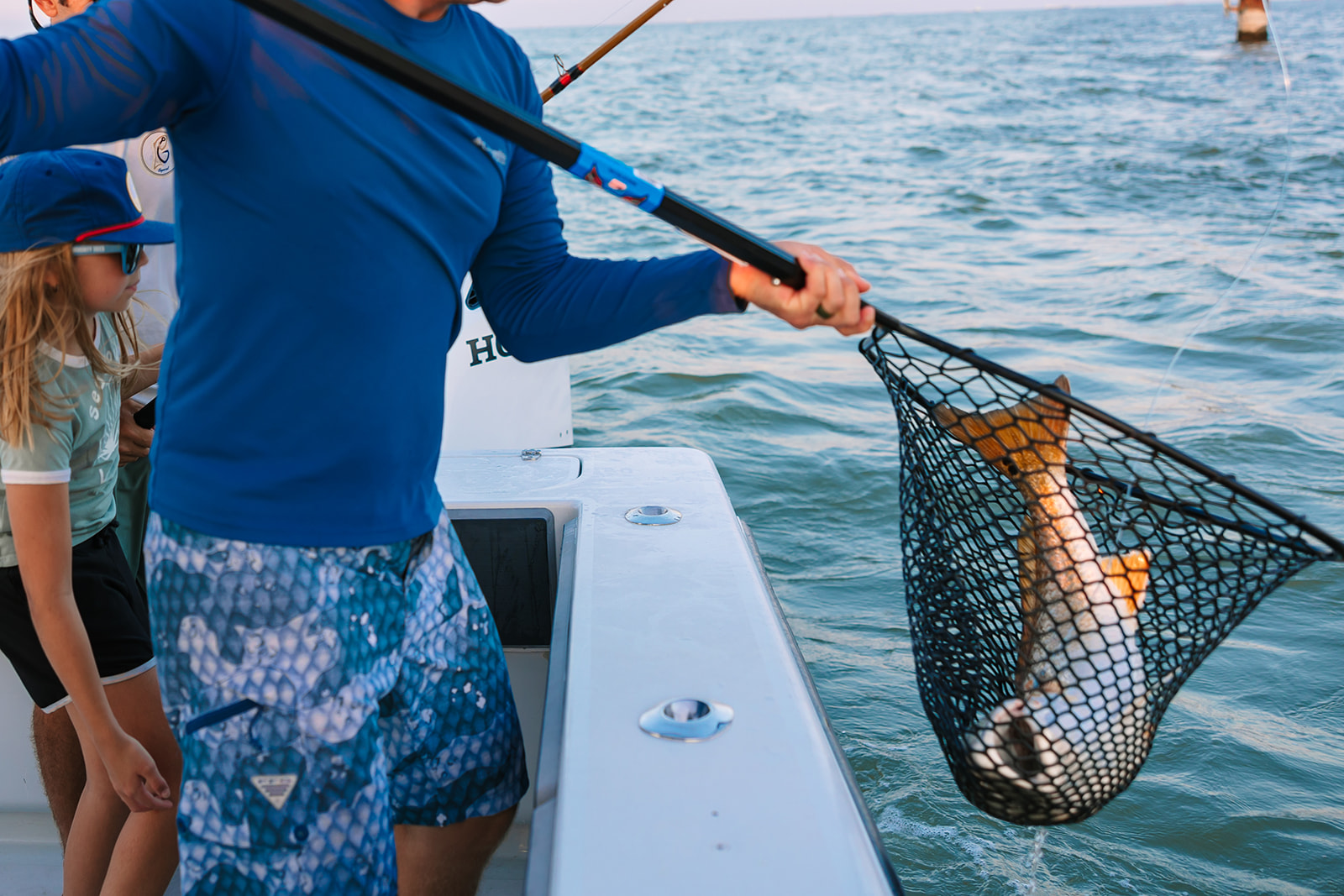 A redfish being netted into the boat on a Galveston Fishing Charter.