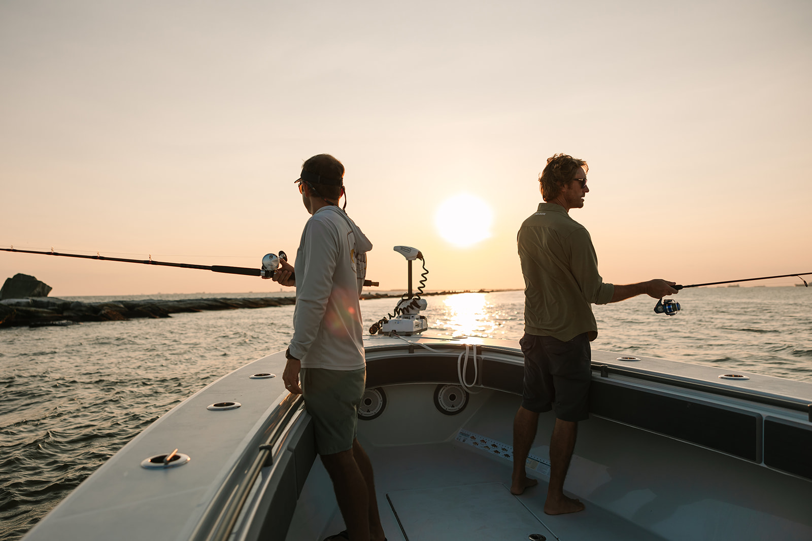 Two friends fish from the bow while watching a Galveston sunset.