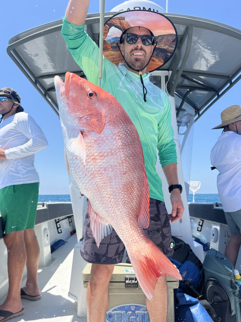 A fishermen poses with a huge red snapper he caught on a Galveston Fishing Charter.