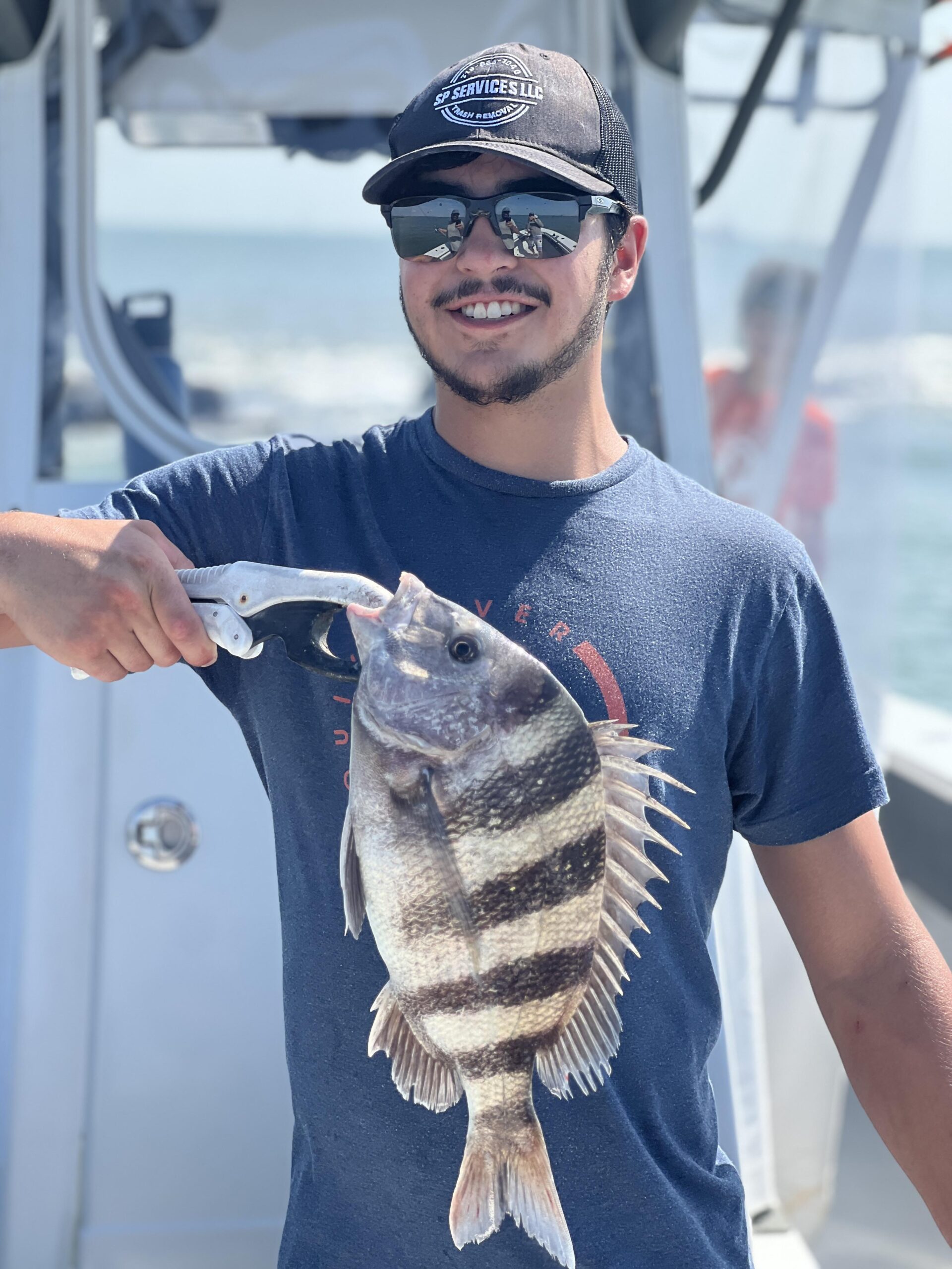 Man holds the drum fish he caught on a Galveston Jetty fishing trip.