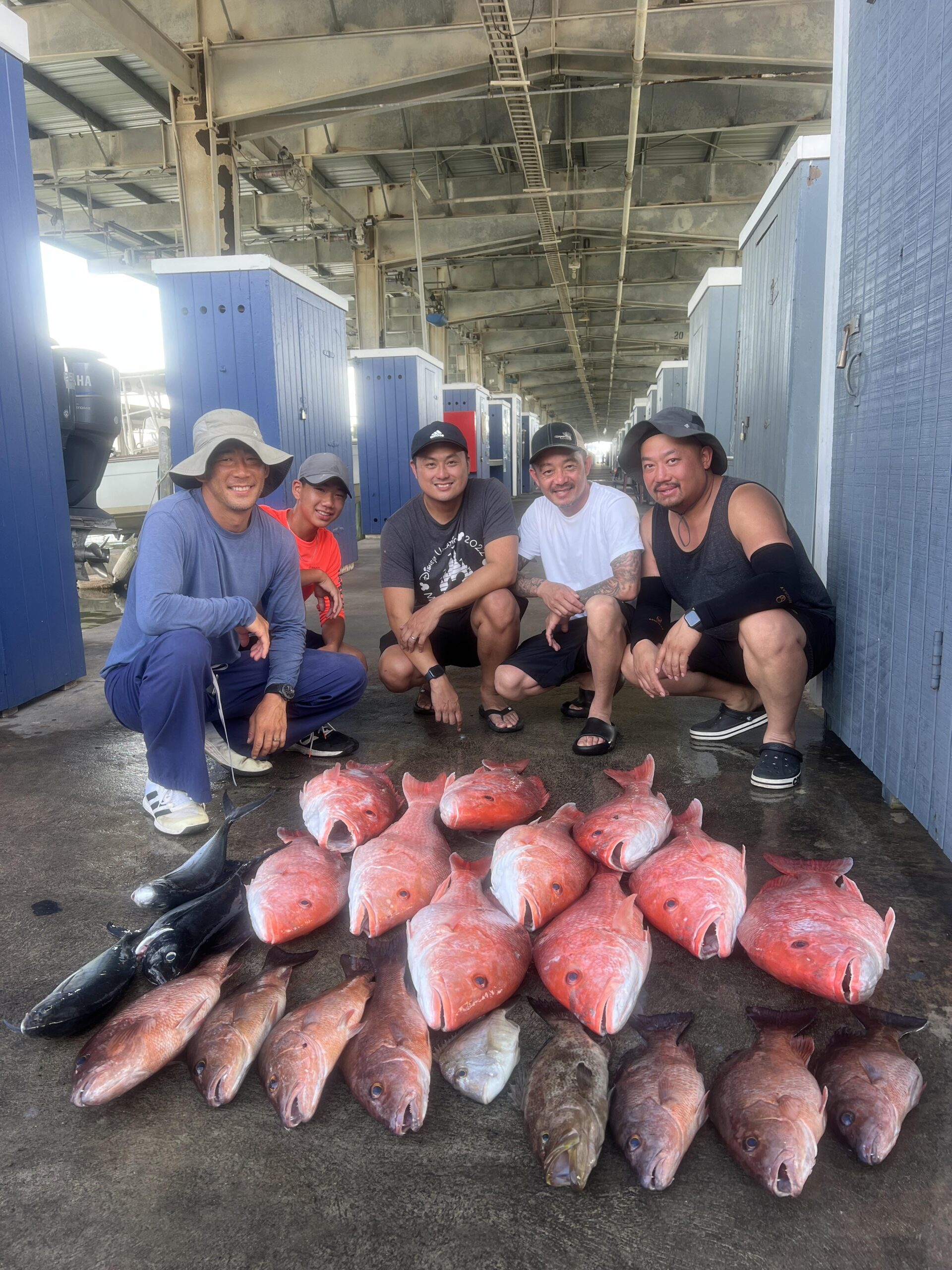 Group of fishermen pose with the many red snapper they caught on a Galveston Deep Sea fishing charter.