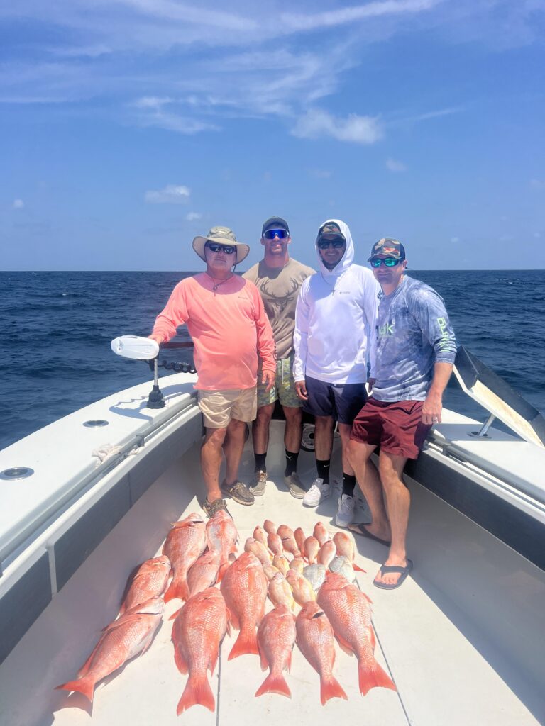 A family of 4 pose with their catch on a Galveston Red Snapper Fishing Charter.