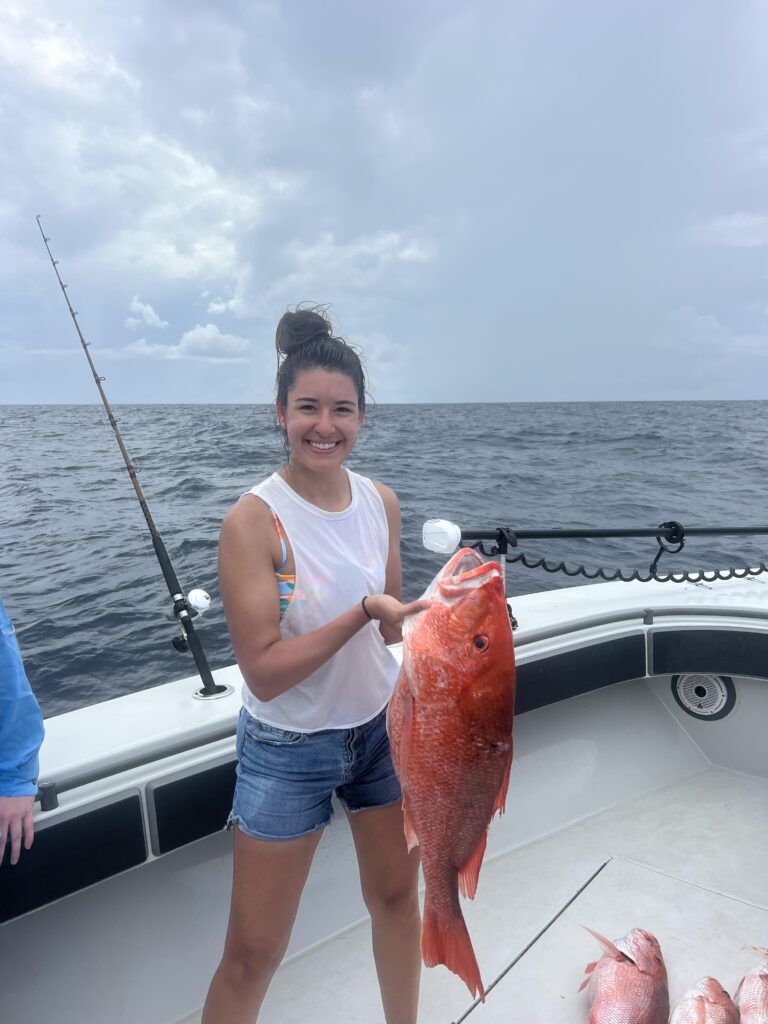 Young woman holds the Red Snapper she caught in Galveston.